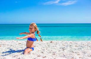 Adorable little sporty girl on white tropical beach photo