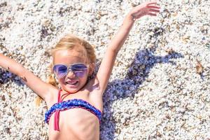 Adorable little girl at tropical beach during summer vacation photo