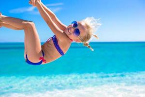 Happy little girl have fun during summer beach vacation photo