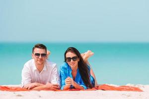 Young couple on white beach during summer vacation. Happy family enjoy their honeymoon photo