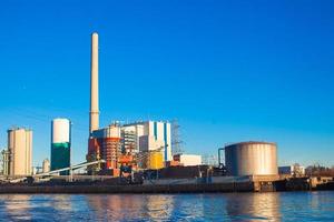 Large factory on a background of blue lake photo