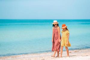 Beautiful mother and daughter at the beach enjoying summer vacation. photo