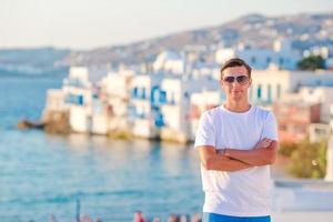 Young man at Little Venice the most popular tourist area on Mykonos island, Greece. photo