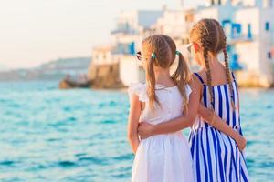 Back view of little kids at Little Venice the most popular tourist area on Mykonos island, Greece. photo