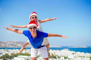 niña y papá feliz en sombreros de santa disfrutan de vacaciones de navidad con hermosa vista foto