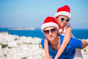 Portrait of family in Santa Hats enjoy Christmas vacation with beautiful view. photo