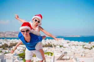 niña y papá feliz en sombreros de santa disfrutan de vacaciones de navidad con hermosa vista foto