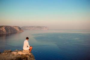 Man outdoor on edge of cliff seashore photo