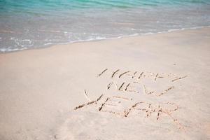 Happy New Year written in the white sand photo