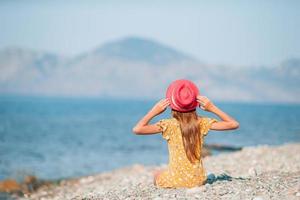 Adorable little girl have fun at tropical beach during vacation photo