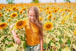 Young girl enjoying nature on the field of sunflowers.