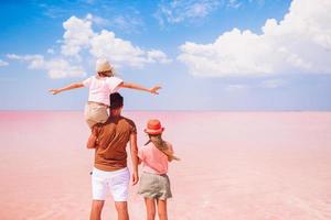 paseo familiar en un lago de sal rosa en un día soleado de verano. foto