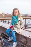 Adorable little girl sitting at Brooklyn Bridge photo