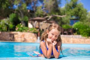 Adorable happy little girl have fun in the swimming pool photo