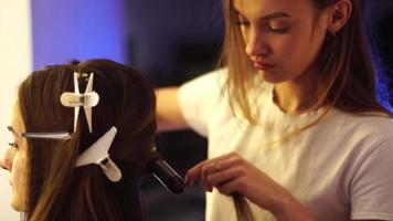 garota jovem estilista faz penteado para uma senhora video