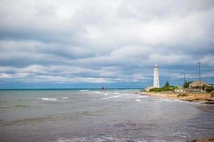 White lighthouse in a bay at sea photo