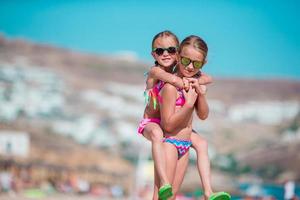 Adorable little girls having fun on summer beach vacation photo