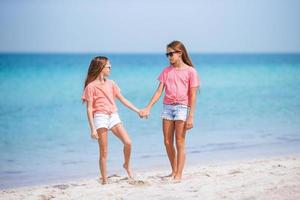 Adorable little girls having fun on the beach photo