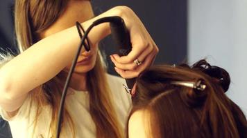 young hair stylist make hairstyle with beautiful woman at salon video