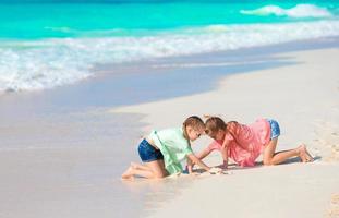 adorables niños pequeños juegan juntos en la playa foto