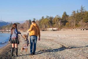 Young parents with their little daughter have fun near the Black Sea photo