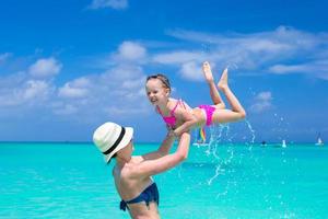 Mother with her cute daughter enjoy the holiday and having fun in water photo