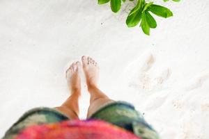 Female feet on white sandy beach photo