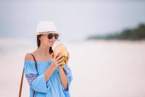 mujer joven bebiendo leche de coco durante las vacaciones tropicales foto