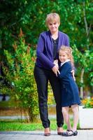 Grandmother brings her granddaughter to school. Adorable little girl feeling very excited about going back to school photo