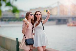 Young tourist friends traveling on holidays outdoors smiling happy. Caucasian girls making selfie background big bridge photo