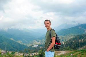 Tourist man in mountains in the background of fog photo