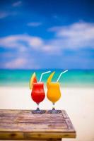 Two tasty alcoholic cocktails on background of turquoise sea photo