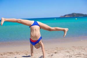 Adorable little girl on tropical white sandy beach photo