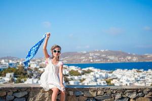 Little girl outdoors background famous village on Mykonos Island, in Greece photo