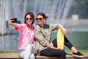 chicas caucásicas haciendo selfie fondo gran fuente. jóvenes amigos turistas que viajan de vacaciones al aire libre sonriendo felices. foto