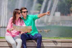 pareja romántica junto con el mapa de la ciudad al aire libre. amantes felices disfrutando del paisaje urbano con monumentos famosos. foto