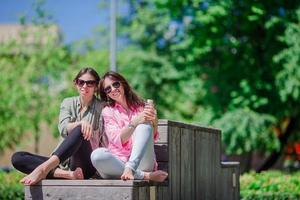 niñas urbanas jóvenes felices en la ciudad europea. turistas caucásicos divirtiéndose juntos al aire libre foto
