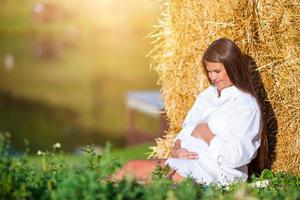 Pregnant woman in outdoor park, warm weather photo