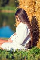 Pregnant woman in outdoor park, warm weather photo