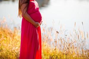Pregnant woman in outdoor park, warm weather photo