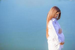 Pregnant woman in outdoor park, warm weather photo