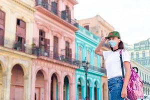 Tourist girl in popular area in Havana, Cuba. Back view of young woman traveler smiling photo