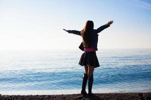 mujer joven divertirse en vacaciones de invierno en la playa foto