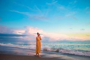 mujer tendida en la playa disfrutando de las vacaciones de verano mirando al mar foto