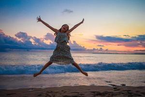 Little happy funny girl have a lot of fun at tropical beach playing together photo