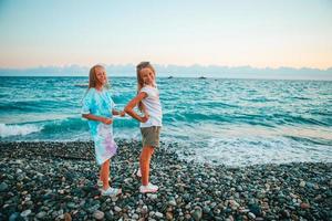 Little happy funny girls have a lot of fun at tropical beach playing together photo