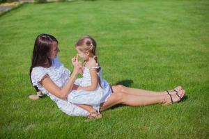 Little girl and her young mother having fun in the yard photo