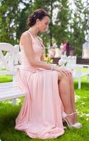 Beautiful young girl in a long dress at the ceremony outdoors photo