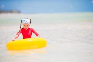 Portrait of happy child with inflatable rubber circle having fun on the beach photo