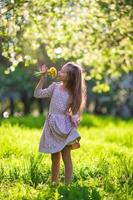 adorable niña en el floreciente jardín de manzanas de primavera al aire libre foto